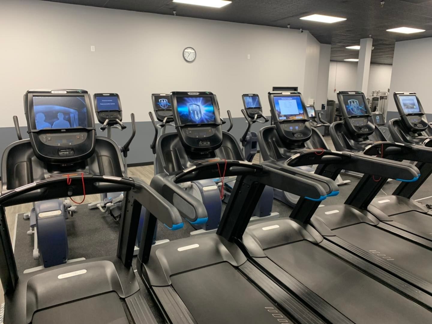 Row of Precor cardio machines on the gym floor at Unlimited Fitness LLC